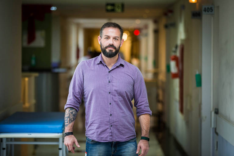 Em pé, em um corredor de hospital, o analista de sistemas Jacson Fressato, 37, criou o robô Laura que identifica pacientes com perfil para desenvolver sepse