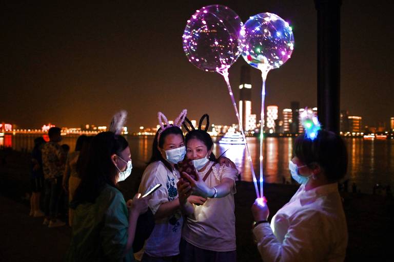 Pessoas tiram foto no parque Hankou, em Wuhan, antes o epicentro da pandemia na China