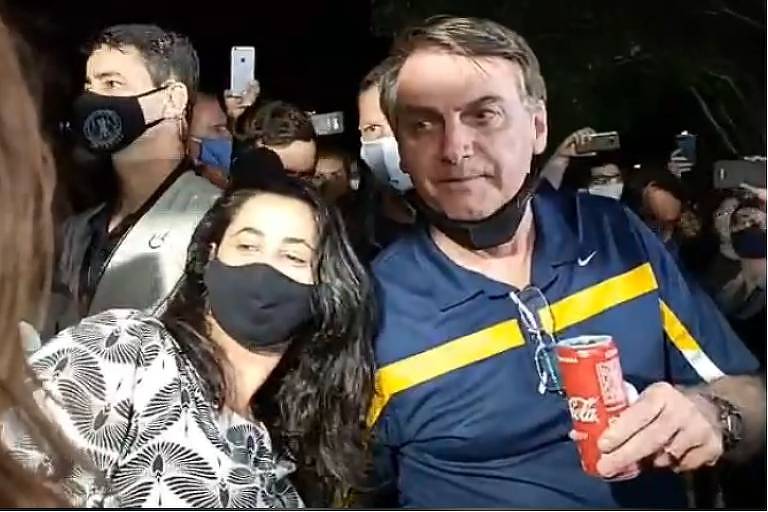 O presidente Jair Bolsonaro vai a barraca de cachorro-quente e tira fotos com apoiadores na noite deste sábado (23.mai.2020), em Brasília