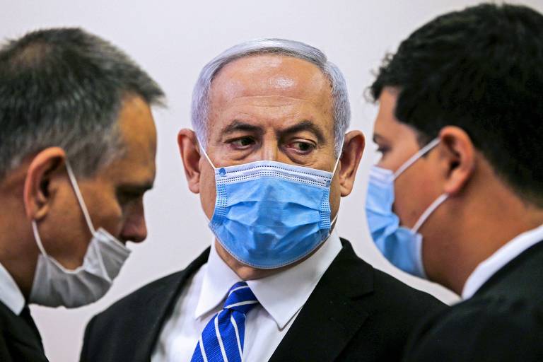 Usando máscara, o primeiro-ministro de Israel, Binyamin Netanyahu, fala com seu advogado durante seu julgamento em Jerusalém por corrupção