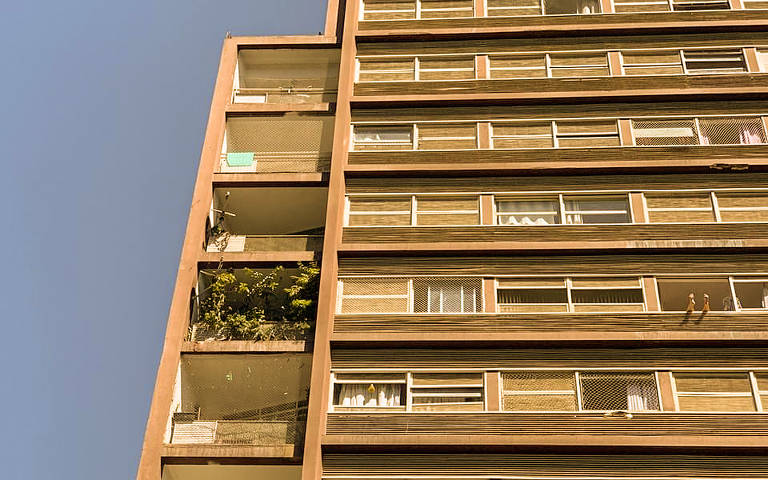 Pessoa toma sol em prédio da zona central da cidade de São Paulo