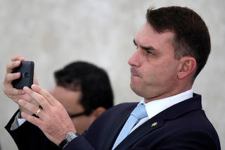Rio de Janeiro State Senator Bolsonaro listens to Brazil's President at media statement in Brasilia