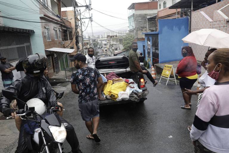 Veículo leva corpos após operação no Complexo do Alemão, no Rio, em que 12 morreram