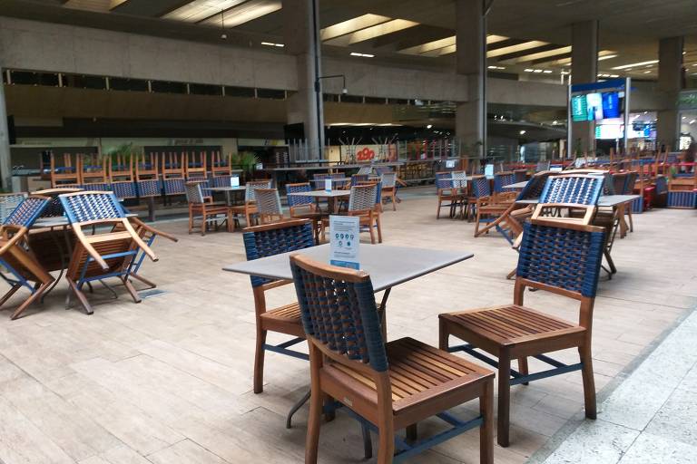 O aeroporto de Confins, com mesas vazias e cadeiras empilhadas, teve o fluxo de passageiros reduzido durante a pandemia