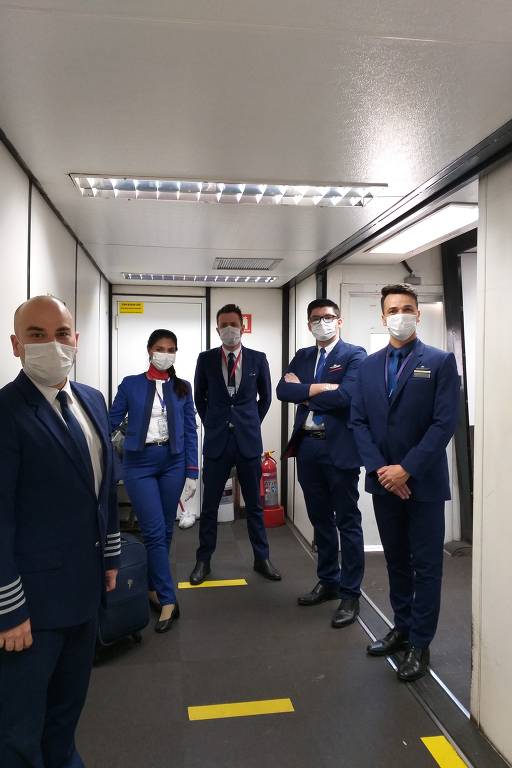 Tripulação usa máscara em voo da Latam de Belo Horizonte para São Paulo; da esquerda para a direita: o piloto João Santos, 41; auxiliar de comissário Eline Pires, 41; o copiloto Lucas Favarin, 32; o auxiliar de comissário César Panda, 24; o comissário Flávio Tonini,38