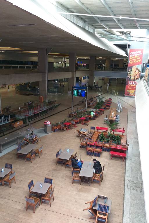 Com capacidade para até 700 pessoas, a área de alimentação do aeroporto de Confins tem mesas vazias e cadeiras empilhadas