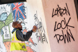 Graffiti artist Nathan Bowen paints a street art mural in the Hackney neighborhood of London, on April 20, 2020. (Suzanne Plunkett/The New York Times)