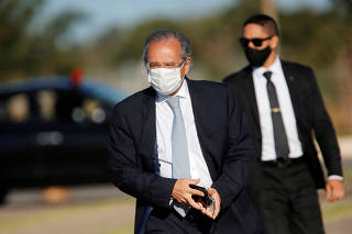 Brazil's Economy Minister Paulo Guedes walks before a national flag hoisting ceremony in front the Alvorada Palace, amid the coronavirus disease (COVID-19) outbreak in Brasilia