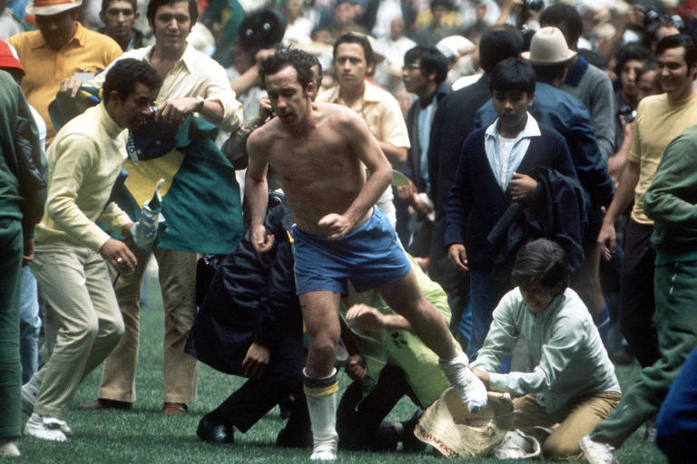Torcedores que invadiram o gramado do estádio Azteca arrancam peças de roupa de Tostão durante a comemoração do título da seleção