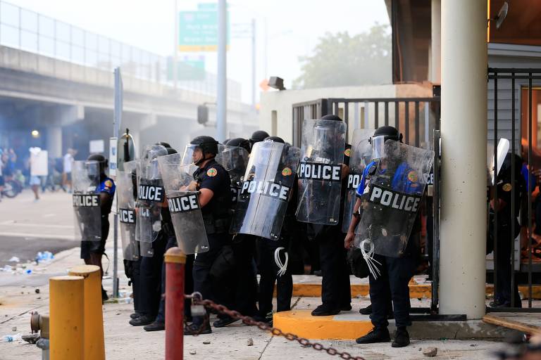 Policiais se protegem durante manifestação em Miami