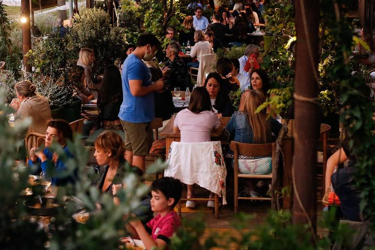 Pessoas jantam em restaurante próximo à praia de Barceloneta, em Barcelona