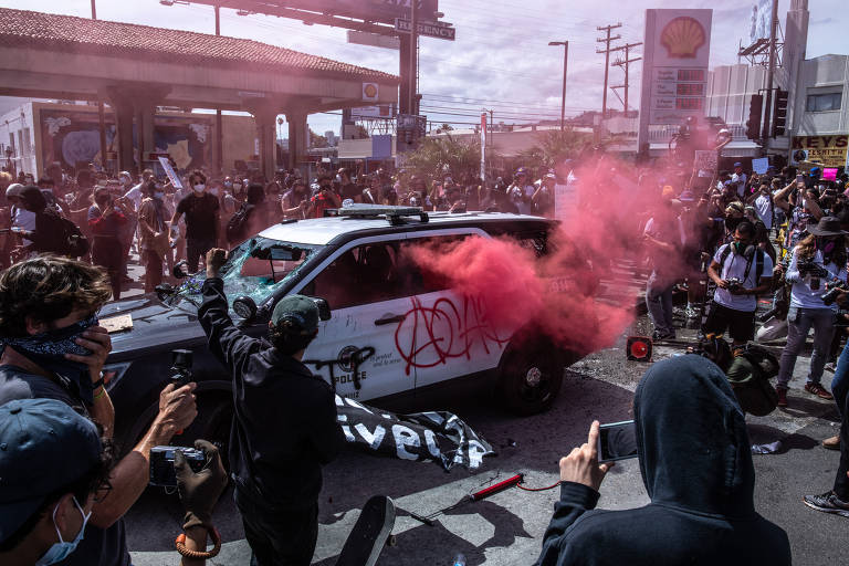 Fumaça sai de veículo da polícia vandalizado por manifestantes em Los Angeles