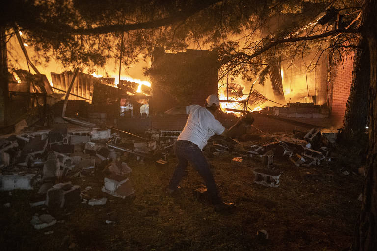 Manifestante joga pedras contra agência de correio incendiada em Minneapolis