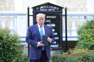 U.S. President Trump holds up Bible during photo opp in front of St John's Church in Washington