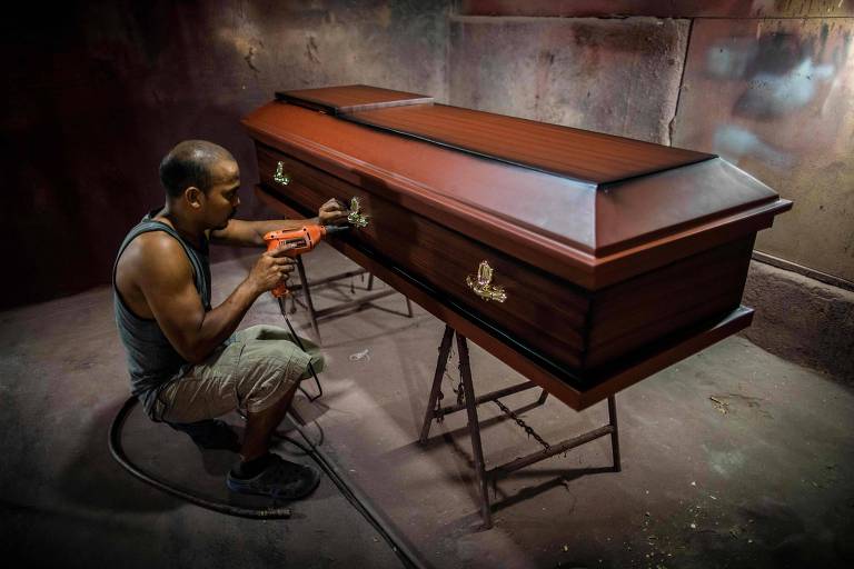 Trabalhador constrói caixão em casa funerária em Manágua