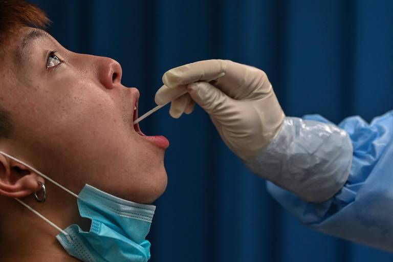 Profissional da saúde realiza teste de Covid em um paciente em Wuhan, local considerado epicentro da pandemia de Covid, na China