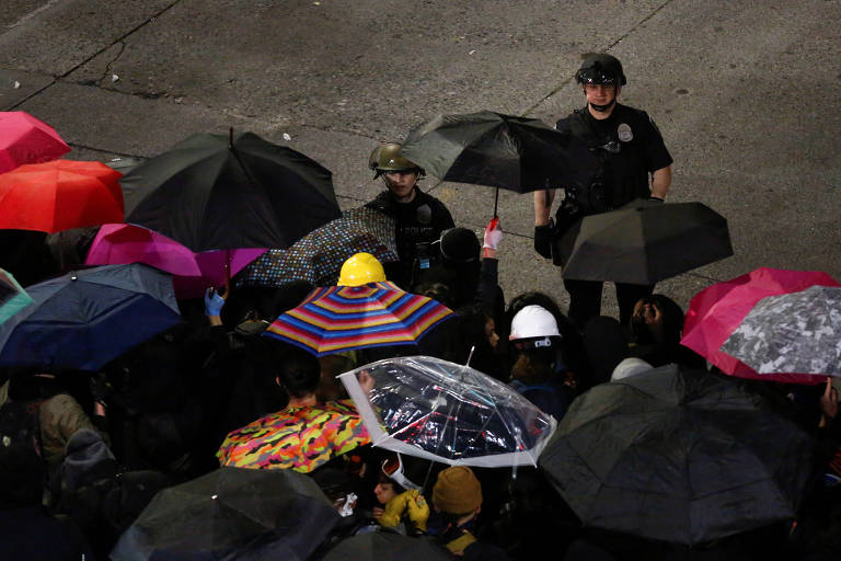 Policiais observam manifestantes durante ato contra a morte de George Floyd em Seattle