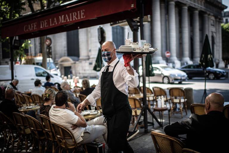 Um funcionário de máscara no Cafe de la Mairie, em Paris  
