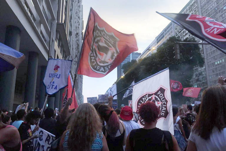 No Rio, uma bandeira vermelha destoa das demais na aglomeração de gente que se reúne no ato pela educação e contra o presidente Jair Bolsonaro em frente à Igreja da Candelária, no Rio: “Policiais Antifascismo”, ela diz. 
Foto: Júlia Barbon/Folhapress