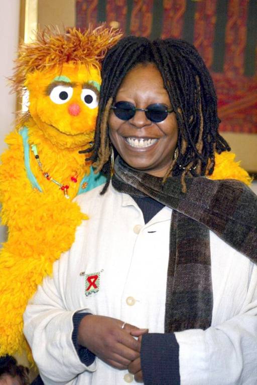Whoopi Goldberg ao lado do boneco Kami, do Muppet Show, em evento para discutir o problema do preconceito contra portadores do vírus HIV