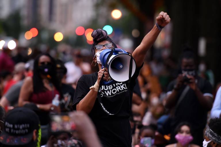 Manifestante com megafone protesta durante ato em frente ao Lafayette Park, próximo à Casa Branca, em Washington