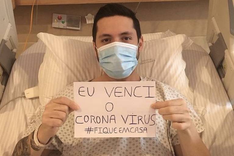 Imagem mostra um jovem rapaz, numa cama, segurando uma folha com os dizeres "eu venci o coronavírus".