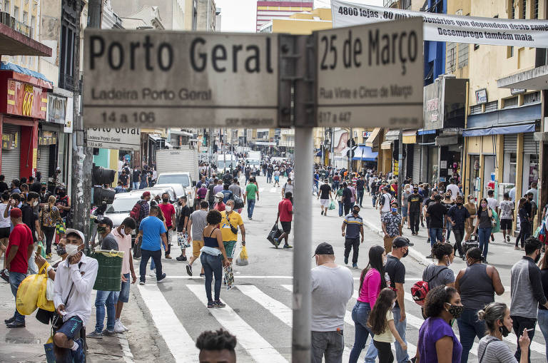 Reabertura gradual do comércio em Sao Paulo; consumidores e vendedores ambulantes circulam na rua 25 de Março 