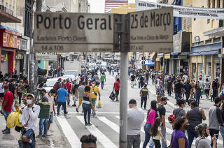 Reabertura gradual do comercio em Sao Paulo. Consumidores e vendedores ambulantes circulam na rua 25 de Marco no primeiro dia de reabertura gradual do comercio
