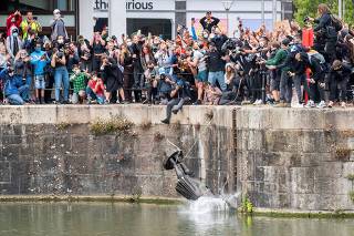 FILE PHOTO: The statue of Edward Colston falls into the water after protesters pulled it down in Bristol