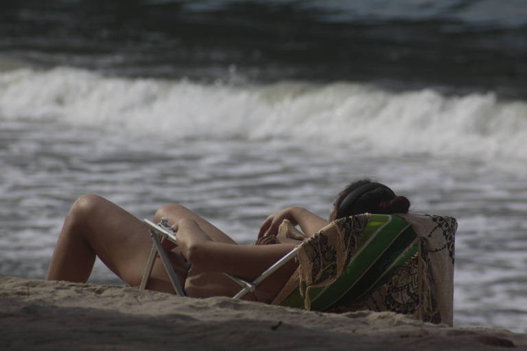 Banhista toma banho de sol em praia do litoral norte de SP