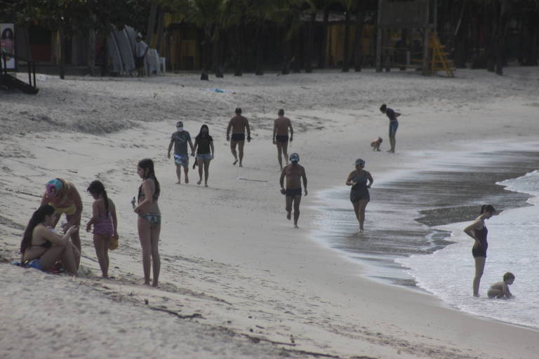 Banhistas aproveitam o dia de sol em praia do litoral norte de SP