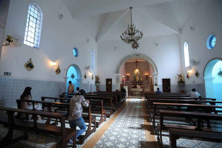 Fiéis rezam dentro da capela Nossa Senhora do Rosário, no centro de Guarulhos (Grande SP), na manhã desta sexta-feira (12). Templos podem abrigar até 25% de sua lotação, segundo determinado pela prefeitura  