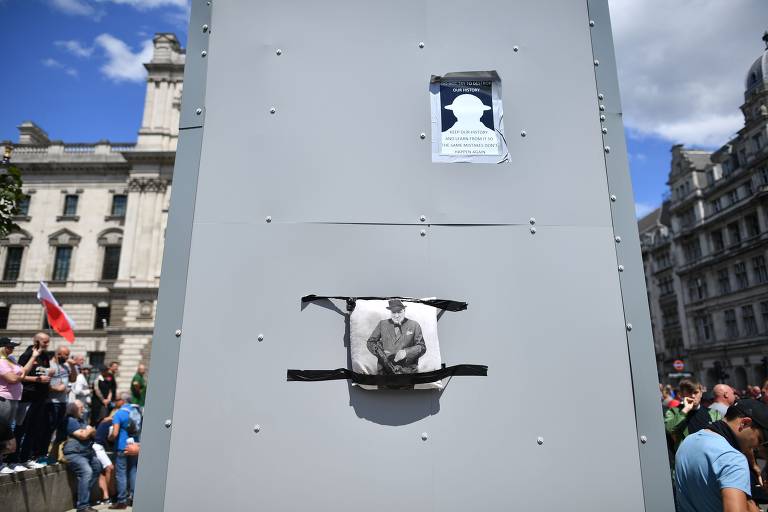 Um tapume com o retrato do primeiro-ministro Winston Churchill foi colocado ao redor de sua estátua enquanto grupos nacionalistas se reúnem na Praça da Parlamento, em Londres
