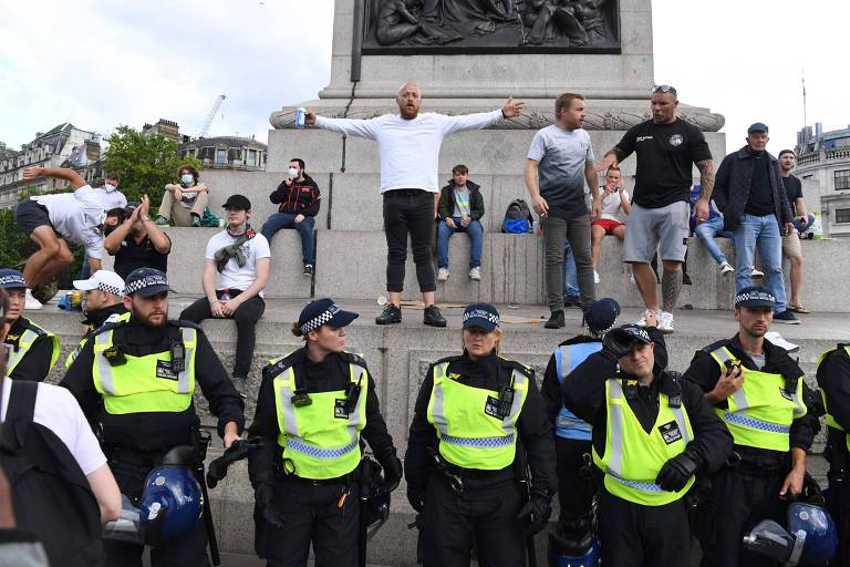 Policiais ao lado de manifestantes que pedem por não violência na Trafalgar square durante ato antirracismo em Londres