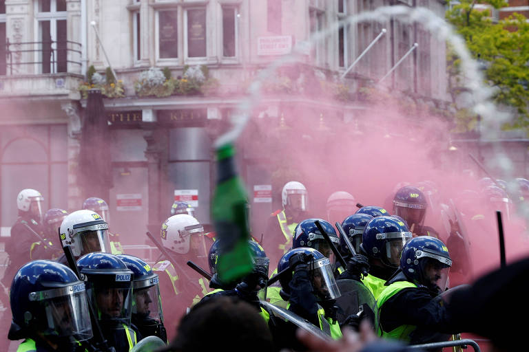 Policiais durante confronto com manifestantes em Londres