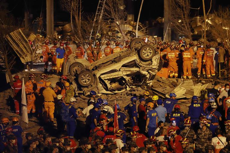 Equipe de resgate procura sobreviventes nos escombros de prédio danificado pela explosão de um caminhão-tanque na China