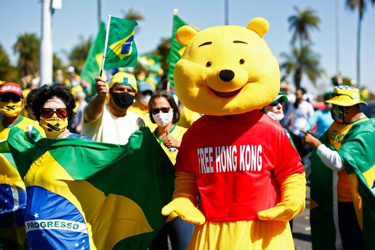 Manifestante com uma fantasia de Ursinho Puff, se une aos apoiadores do presidente Bolsonaro, durante um protesto próximo da sede do exército, contra a decisão do governador do Distrito Federal, Ibaneis Rocha (MDB), de impedir que multidões participem de manifestações em meio à pandemia de coronavírus, em Brasília.