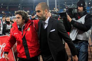 FILE PHOTO: Almeria's coach Lillo and Barcelona's coach Guardiola leave the pitch at the end of their Spanish first division soccer match against Barcelona in Almeria.