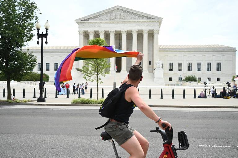 Pouco após o anúncio da decisão, homem com a bandeira símbolo do movimento LGBT celebra o resultado em frente à Suprema Corte dos EUA, em Washington 