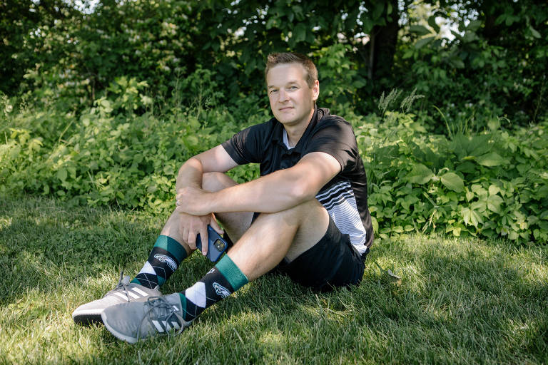 Steven Young, um apostador esportivo que agora investe no mercado financeiro, sentado com sua roupa de treinador em um gramado
