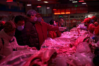 Customers wearing face masks buy pork meat at the Xinfadi wholesale market, as the country is hit by an outbreak of the novel coronavirus disease (COVID-19), in Beijing