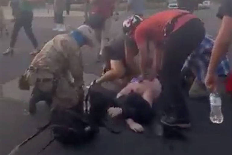 Homens tentam ajudar ferido durante ataque de milícia em Albuquerque, Novo México, nos EUA
