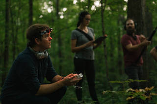 Stuart Hyatt, left, with Erica Penna and Nathan Ferreira, recording the high-frequency sounds of bats for the album ?Ultrasonic,? near Bloomington, Ind., Aug. 5, 2019. (Anna Powell Denton via The New York Times)