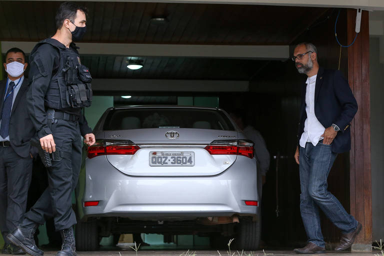 O blogueiro Allan dos Santos conversa com policiais federais que fizeram operação de busca e apreensão na casa dele na manhã de 16 de junho, no âmbito do inquérito das fake news no STF 