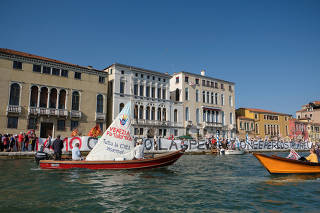 Protesters form a human chain next to the water, demonstrating against mass tourism in Venice