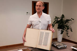 Ukrainian opposition politician Medvedchuk shows a fragment of the Gutenberg Bible during an interview in Kyiv