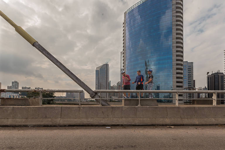 Homens caminham na Ponte Estaiada.