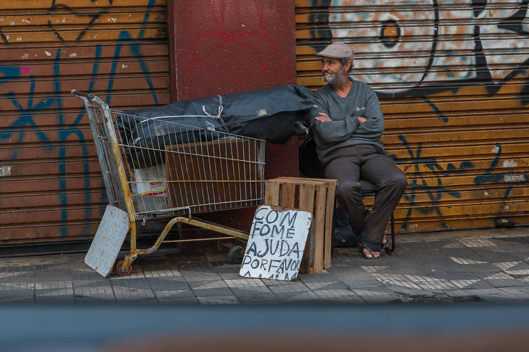 Homem usa cartaz para pedir ajuda para comer, na região da Sé.