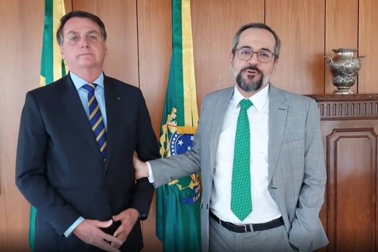 Ao lado do presidente Jair Bolsonaro, Abraham Weintraub, na ocasião em que leu texto de despedida do Ministério da Educação, na quinta-feira (18)