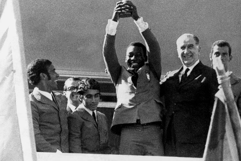 Em Brasília, no dia 23 de junho de 1970, Pelé levanta a taça Jules Rimet conquistada no México. Ao seu lado, está o presidente Emílio Garrastazu Médici
